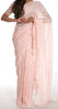 Model draped in a baby pink lace saree with scalloped edging. Model is also wearing a short sleeve crop top and saree petticoat underneath in matching color.