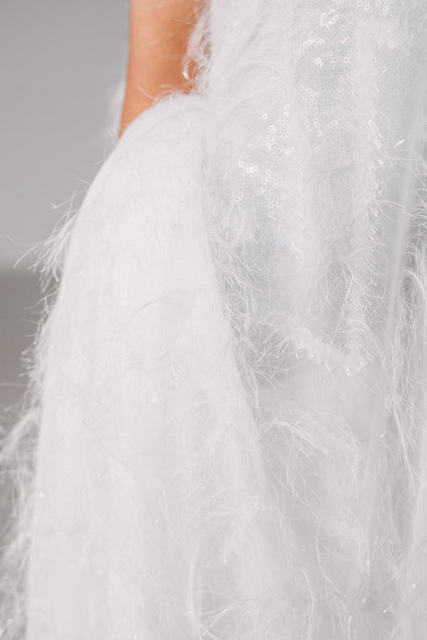 Detailed close up of a white saree featuring threadwork that creates the illusion of 3D feathers. 