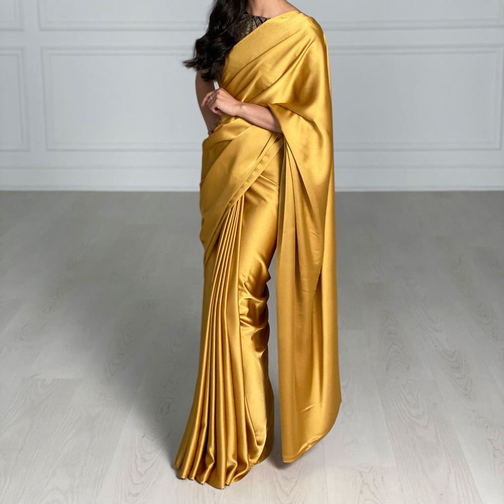 Model draped in a bright yellow satin silk saree.