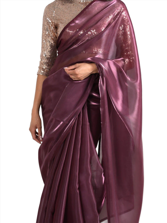 Model draped in a maroon/burgundy organza saree with maroon/burgundy satin border. Model is also wearing a rose gold 3/4 sleeve sequin crop top.